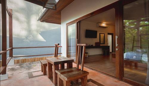 a wooden chair in a room with a window at Sichon Cabana Beach Resort in Sichon