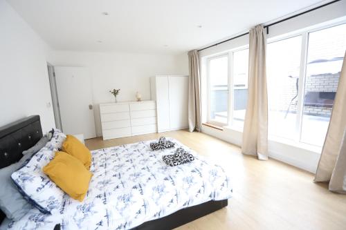 a bedroom with a bed and a large window at Spacious 3-Story Retreat with Rooftop Terrace and Modern Amenities in London