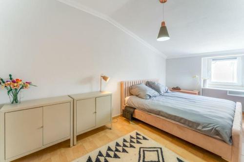 a bedroom with a bed and a dresser and a window at Nazare Townhouse near Lighthouse & Big Waves in Nazaré