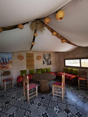 a living room with a couch and a table and chairs at Villa Douira avec piscine, proche d'Essaouira in Essaouira