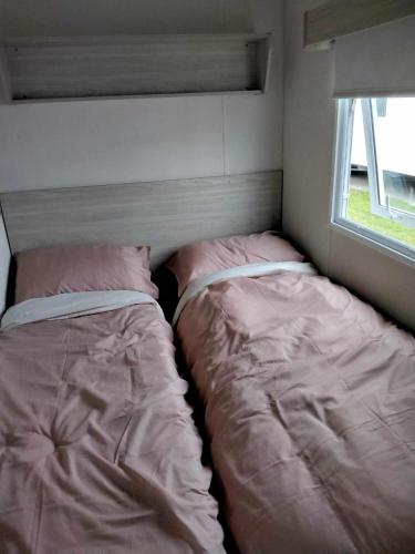 a small bedroom with two beds and a window at 20 Cherry Tree Walk Lyons Robin Hood in in Rhyl