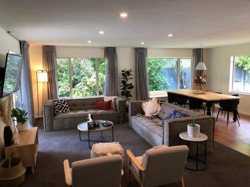 a living room with a couch and a table at Hidden Gem of Christchurch - Sleeps 13 in Christchurch