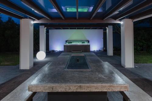 a concrete table in a pavilion with a bed in it at Hidden Gem of Christchurch - Sleeps 13 in Christchurch