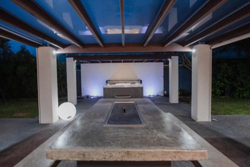 a covered patio with a table and a grill at Hidden Gem of Christchurch - Sleeps 13 in Christchurch