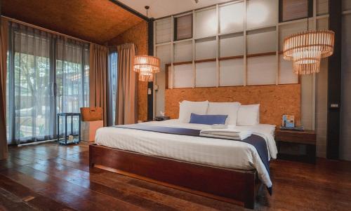 a bedroom with a large bed and a large window at Sichon Cabana Beach Resort in Sichon
