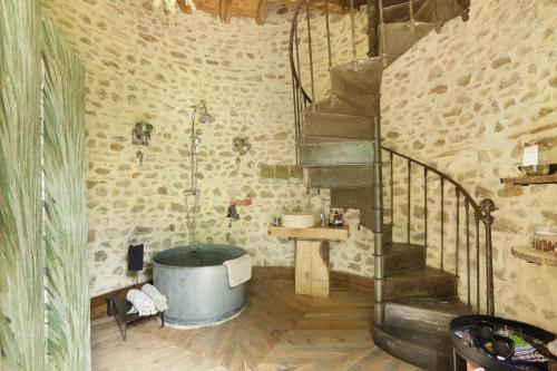 a bathroom with a bath tub and a staircase at ForRest Stone, hébergement insolite 1h de Lyon, St Etienne et Clermont Ferrand in Lay
