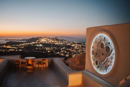 a view of a city at sunset from a building at Luna Santorini Suites in Pirgos