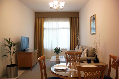 a living room with a table and a couch at Swissôtel Al Murooj Dubai in Dubai