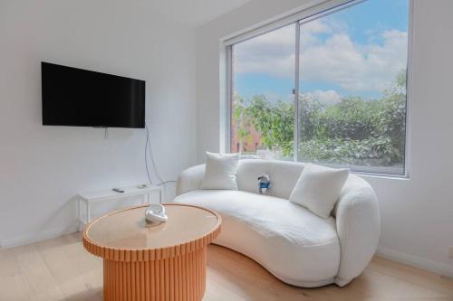 a living room with a white couch and a table at Cozy Studio walk to Park & Water in Sydney