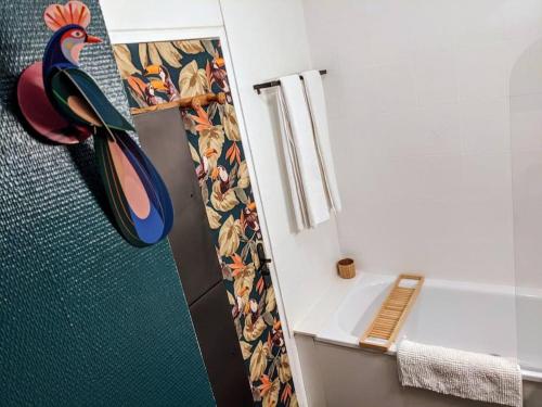 La salle de bains est pourvue d'une douche avec un oiseau sur la porte. dans l'établissement Charmant T2 avec Jardin Proche gare, à Rennes
