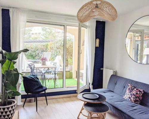 un salon avec un canapé bleu et une table dans l'établissement Charmant T2 avec Jardin Proche gare, à Rennes