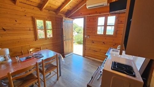 une cuisine avec une table et des chaises dans une cabine dans l'établissement Camping Les Couchants, à Casaglione