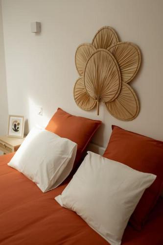 - un lit avec deux oreillers et une fleur sur le mur dans l'établissement La Halte de la tour, à Warcq