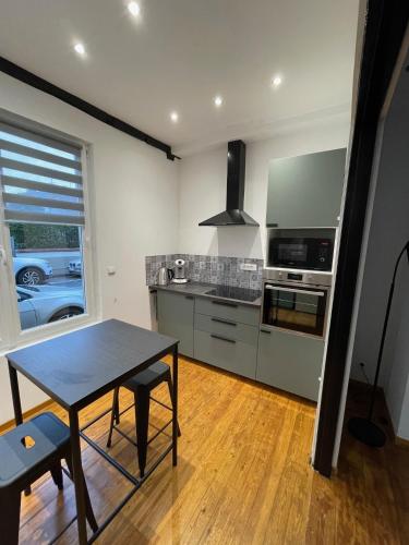 une cuisine avec une table et une cuisinière four supérieur dans l'établissement Gite maison cosy sur Grand-Fort-Philippe, à Grand-Fort-Philippe