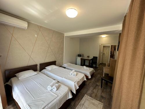 two beds in a hotel room with a mirror at Ave Hotel Victoriei in Bucharest