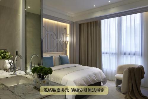 a bedroom with a bed and a sink and a mirror at Boda Hotel in Taichung
