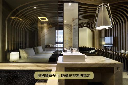 a bathroom with a sink and a couch in a room at Boda Hotel in Taichung