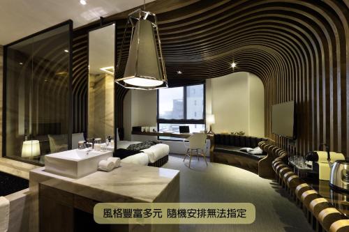 a bathroom with a sink and a living room at Boda Hotel in Taichung