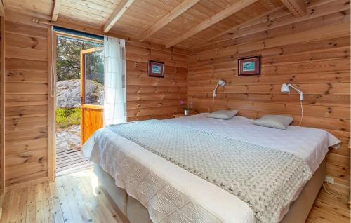 a bedroom with a bed in a wooden cabin at Beautiful Home In Skjeberg With Kitchen in Skjeberg