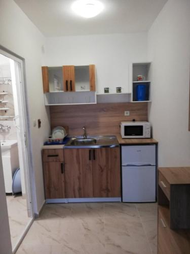 a small kitchen with a sink and a microwave at Ахтопол студио Ралица in Ahtopol