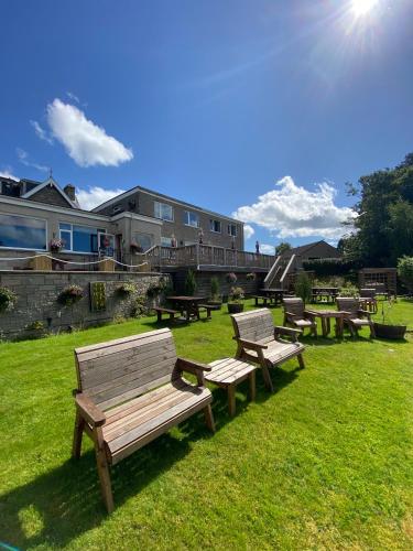 a group of benches sitting in the grass at Craigvrack Hotel & Restaurant in Pitlochry