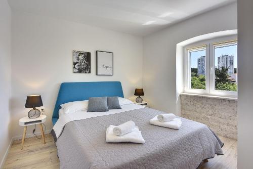 a bedroom with a large bed with towels on it at Nur 200 Meter zum Strand mit Salzwasserpool, Fahrräder, Sonnenterrasse in Pula