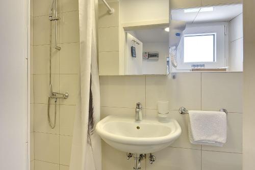 a bathroom with a sink and a shower at Nur 200 Meter zum Strand mit Salzwasserpool, Fahrräder, Sonnenterrasse in Pula