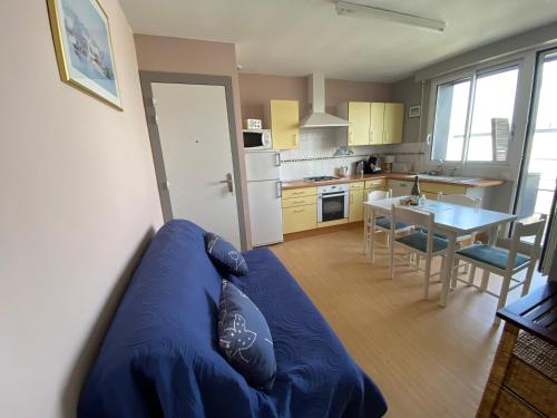 un salon avec un canapé bleu dans une cuisine dans l'établissement Ty Fanch Quiberon, à Quiberon