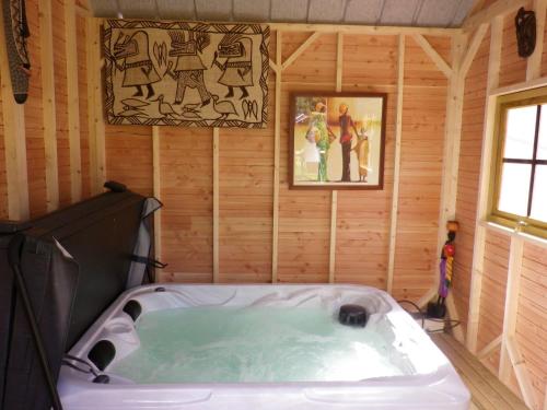 een bad in een kamer met een houten muur bij Ty Fanch Quiberon in Quiberon