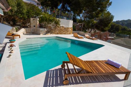 ein großer Pool mit einer Bank und einem Stuhl in der Unterkunft Mora Villa ONLY FAMILIES in Tarragona