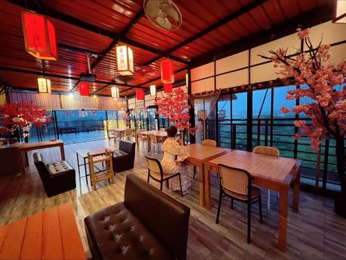a woman sitting at a table in a restaurant at Sakura Yama Resort ซากุระ ยามะรีสอร์ท in Ban Huai Phai