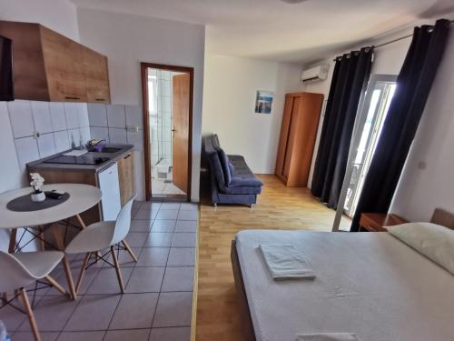 two images of a kitchen and a living room at Apartmani Leženić M in Neum