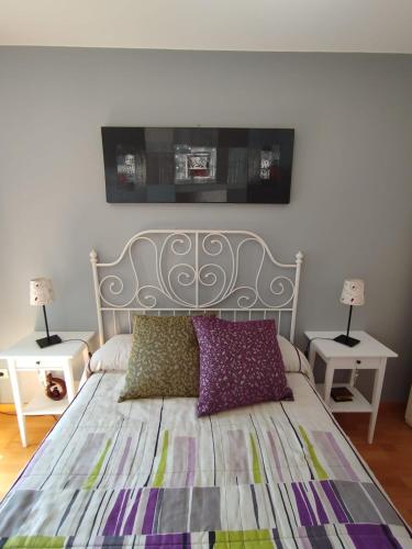 a bedroom with a bed with two tables and two lamps at Acogedor Apartamento En Huesca in Huesca