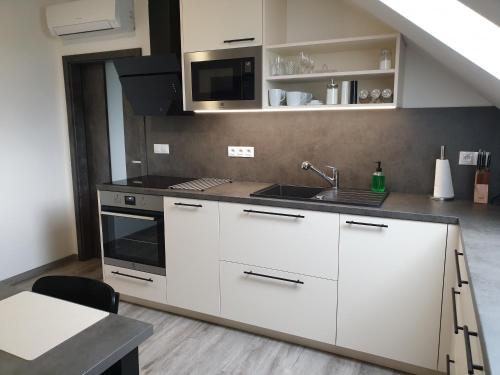 a kitchen with white cabinets and a sink at apartmány Miška Mirkovice in Mirkovice