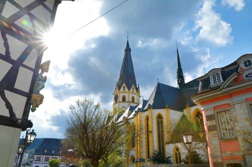 a church with a spire on a city street at Hotel Am Weißen Turm in Bad Neuenahr-Ahrweiler