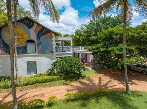 a house with a painting on the side of it at Olive Farm @ Embassy International Riding School in Yelahanka