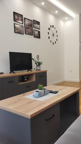 a room with a desk with a clock on the wall at Apartman Pike centar in Trebinje