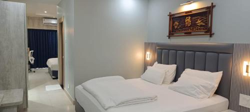 a bedroom with a bed with white sheets and pillows at Hotel Lee Garden Near to Blue Flag Beach 500 Mtrs in Puri