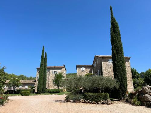 une grande maison en pierre avec deux arbres et une allée. dans l'établissement Château deMappe Villa #9 à Lorgues, à Lorgues