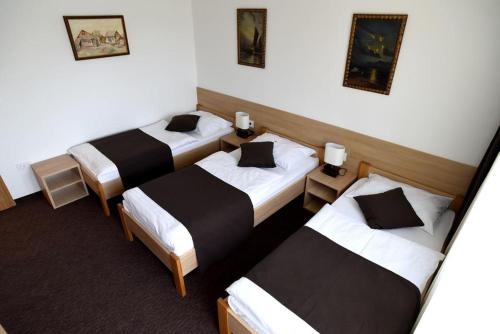 a hotel room with three beds in it at TIM rooms in Velika Gorica
