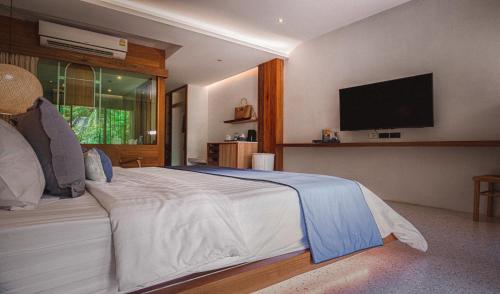 a bedroom with a large bed with a flat screen tv at Sichon Cabana Beach Resort in Sichon