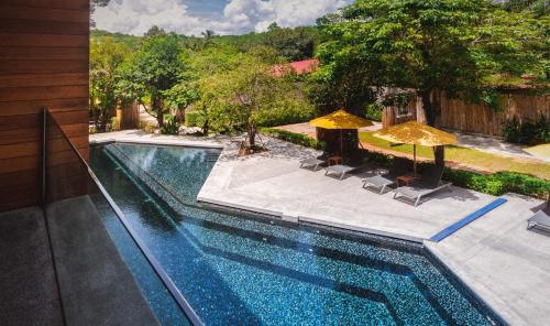 a swimming pool with two umbrellas and chairs and a pool at Sichon Cabana Beach Resort in Sichon