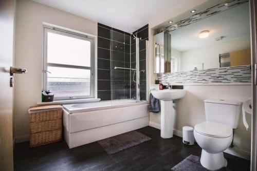 a bathroom with a tub and a toilet and a sink at Inverurie Town Centre 97m2 Maisonette in Inverurie