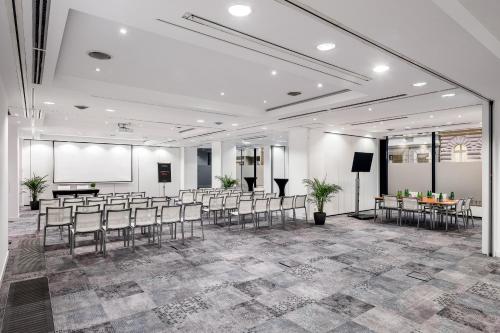a conference room with chairs and a projection screen at Vienna House by Wyndham Andel's Prague in Prague