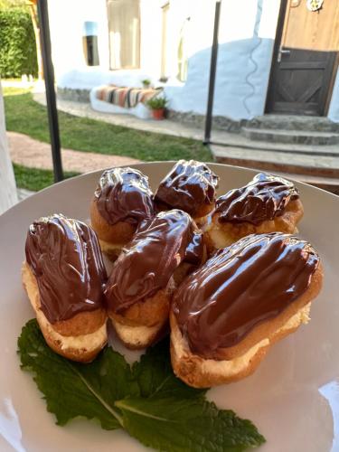 a group of chocolate covered donuts on a plate at Cob Village in Berca