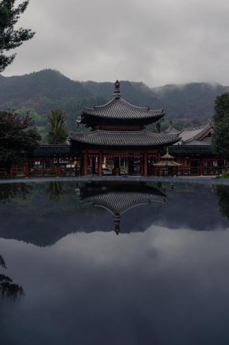 a chinese building with a reflection in a pond at Nost algia S Hotel Hangzhou West Lake & Lingyin Temple 时光漫步S酒店杭州西湖店 Free laundry service, Free fresh ground coffee in Hangzhou