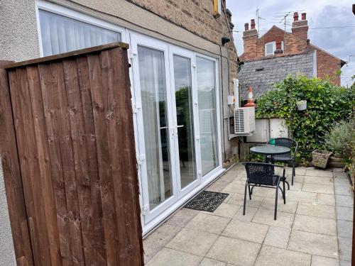 a patio with a wooden fence and a table at Hillcrest Bungalow in Nottingham