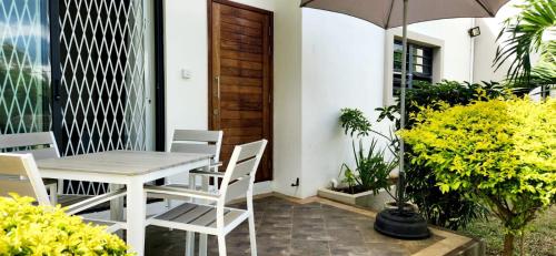 a patio with a table and chairs and an umbrella at La Maison d'Isa in Albion