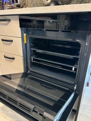 an oven with its door open in a kitchen at Business Park Sofia Cozy Lux & Private Garage Option in Sofia