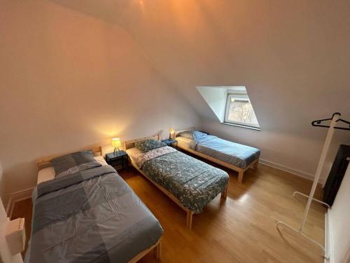 - une chambre mansardée avec 2 lits et une fenêtre dans l'établissement Le Petit Répit - Proche Metz Amnéville Luxembourg, à Serémange-Erzange